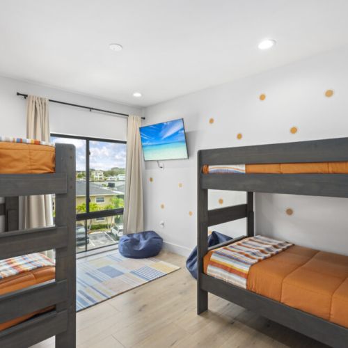 Bright and cheerful with sunny décor, cozy beds, and a mounted TV, this room is perfect for group stays or family getaways.