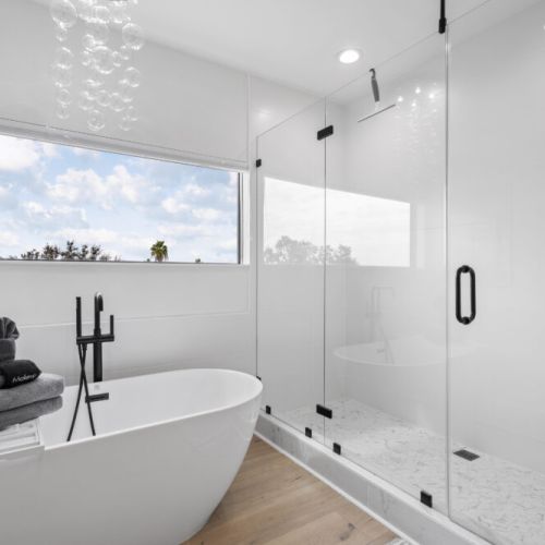 A stunning bubble-style light fixture adds a playful, modern touch to this elegant primary bathroom.