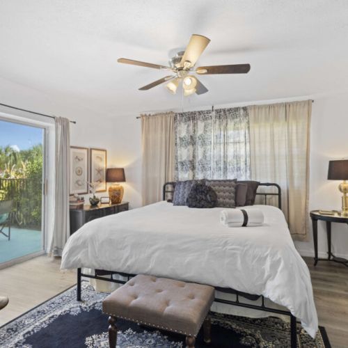 Primary Bedroom equipped with a comfortable king bed, fan, tv, blinds, curtains, ensuite bathroom.
