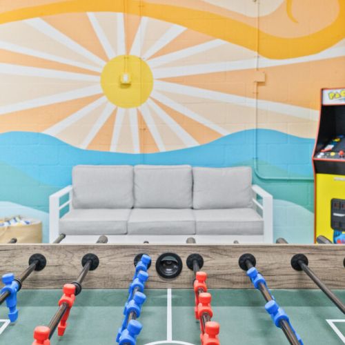Brighten your stay in the game room with a vibrant sun mural that brings coastal energy indoors.