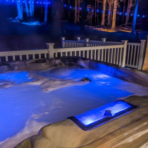 Relax in the hot tub surrounded by the dense forest and string lights.