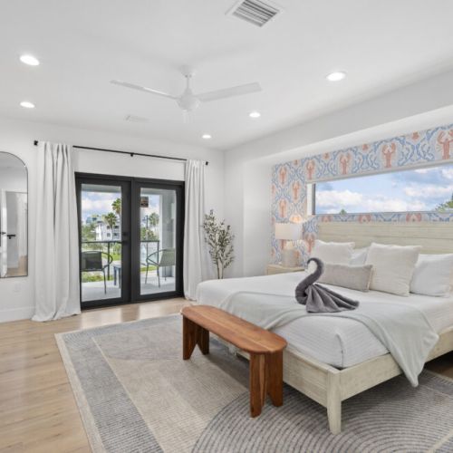 Spacious, luxury primary bedroom. King bed, blackout curtains, lots of natural light, dimmable lighting, ceiling fan, balcony, and ensuite luxury bathroom.
