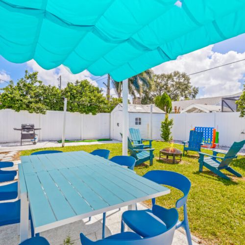 Backyard features ample seating, a grill, and a firepit for relaxing and entertaining.