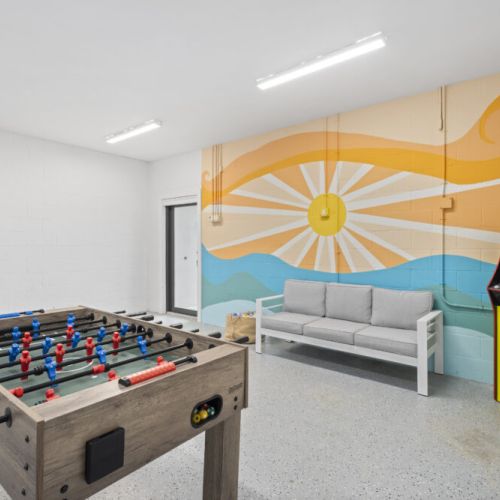 Bring your competitive spirit to this colorful game room, complete with an eye-catching beach mural that makes the perfect Instagram backdrop for family fun.