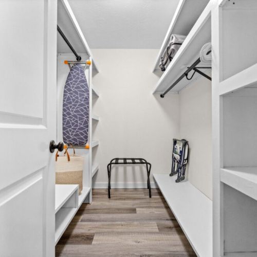 Main bedroom walk-in closet. Iron and ironing board.