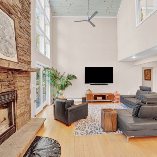 Fireplace, 75" 4k tv, speakers, comfortable lounge area, basket of blankets.