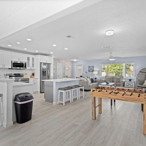 Enjoy the open-concept kitchen and main living area, where modern amenities meet fun with a foosball table for endless entertainment.