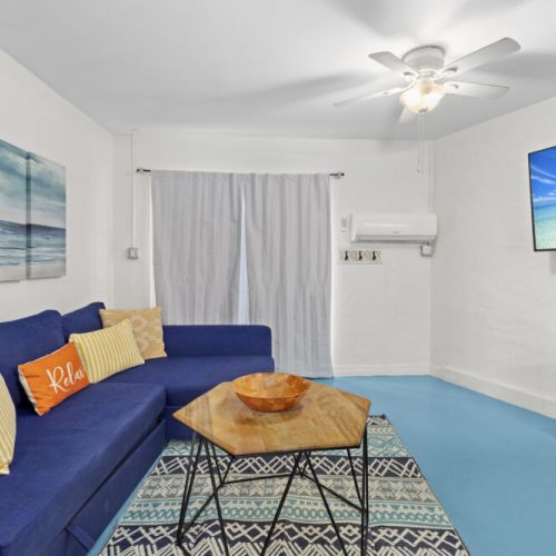 Spacious living room featuring cozy seating, coastal-inspired décor, and plenty of natural light for the perfect place to unwind after a day at the beach.