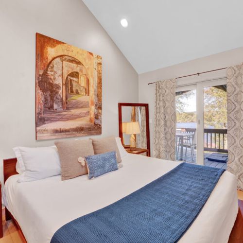 Main level King bedroom. Lake views, deck access, fan, dresser, dimmable lights, lamps, night stands, mini split.