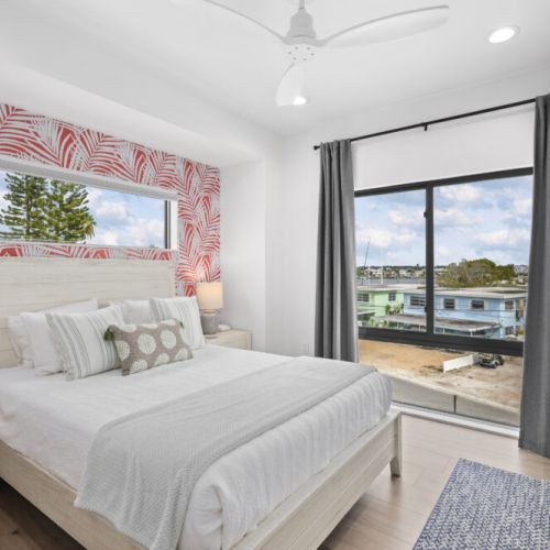 Relax in a bright bedroom with scenic bay views and a mounted TV for your comfort and entertainment