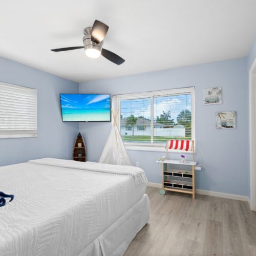 King bedroom with a mounted TV, perfect for relaxing and unwinding after a day at the beach.