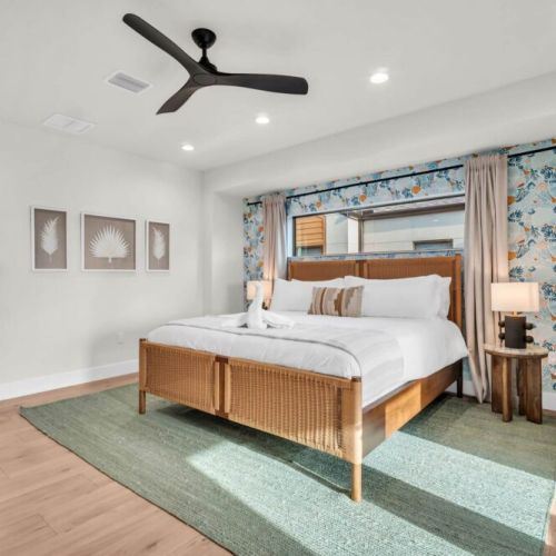 Spacious, luxury primary bedroom. King helix bedroom, black out curtains, lots of natural light, dimmable lighting, ceiling fan, balcony, desk area, and ensuite luxury bathroom.