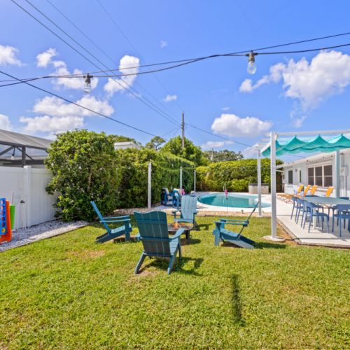 Sprawling beachy backyard with pool, hot tub, and plenty of space for fun and relaxation.