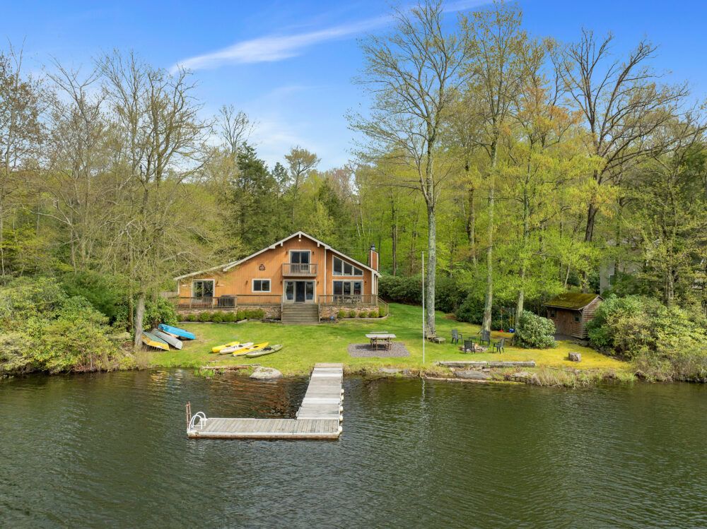 View of the Secluded Lakefront Escape from the lake. Big deck, lots of loungers in the yard.